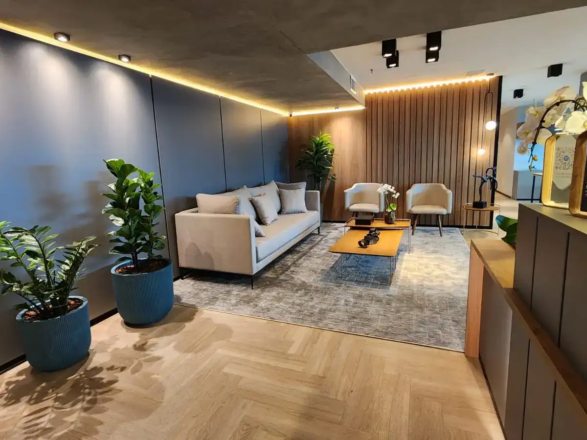 Lounge da BROffices com sofás, poltronas e acabamentos em madeira