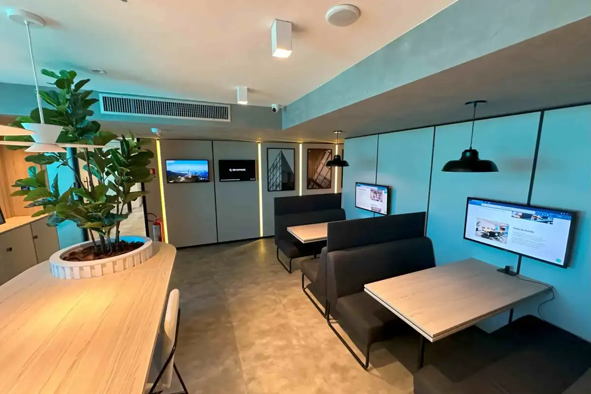 Coworking da BROffices com mesas de madeira, bancos estofados e plantas