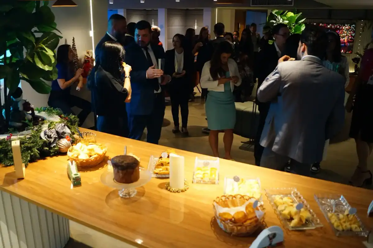 Profissionais em um evento de networking na unidade Number One, em volta de uma mesa de comidas