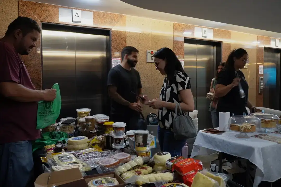 Mesas de fornecedores e clientes durante o Mercadinho