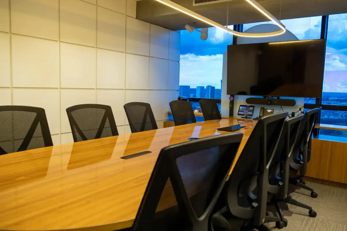 Sala Ipê Amarelo do Number One com mesa de madeira, tela, câmera de videoconferência e painel de controle