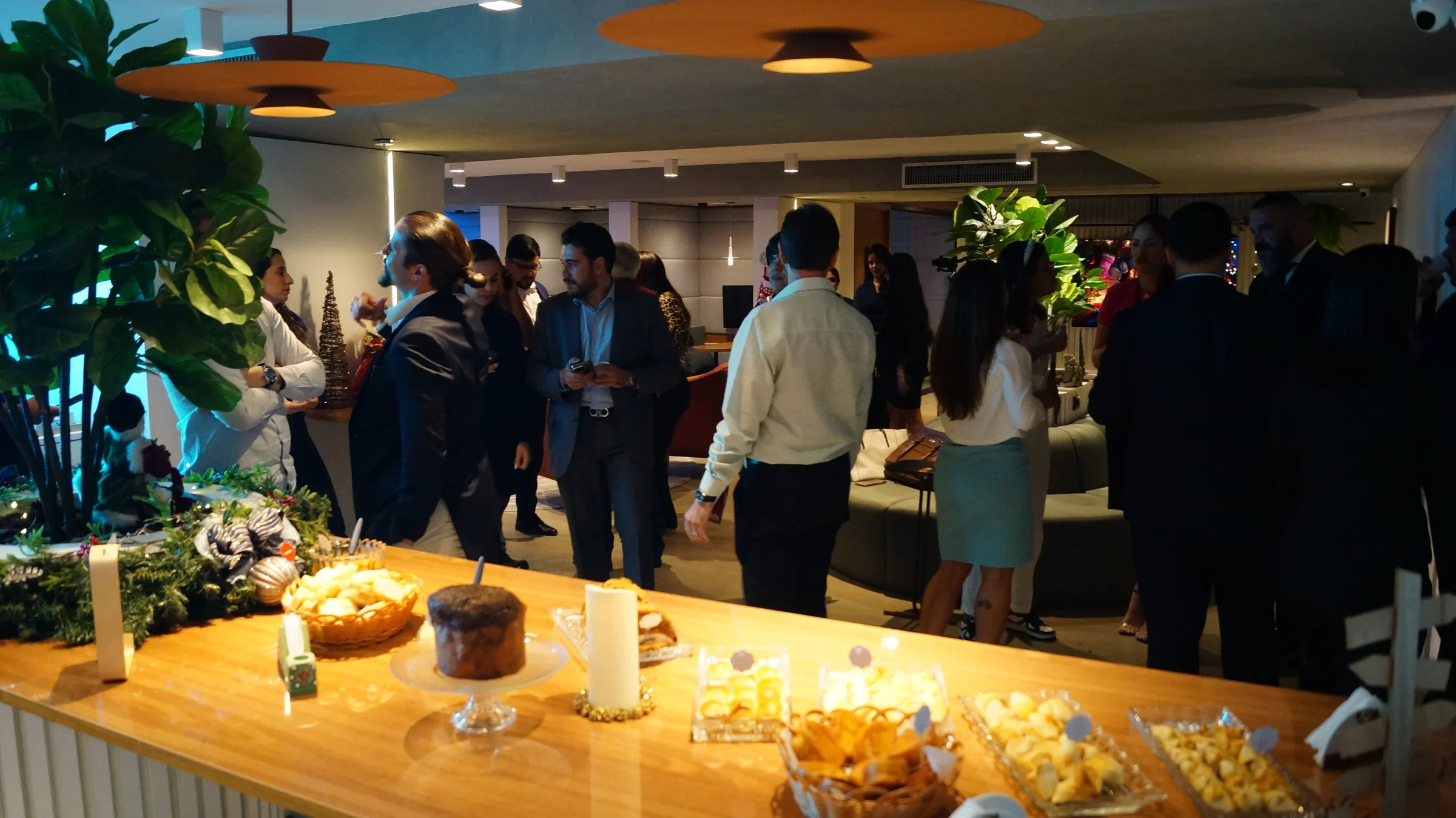 Clientes e convidados reunidos ao redor da mesa de petiscos em um Happy Hour na unidade Number One, em Brasília