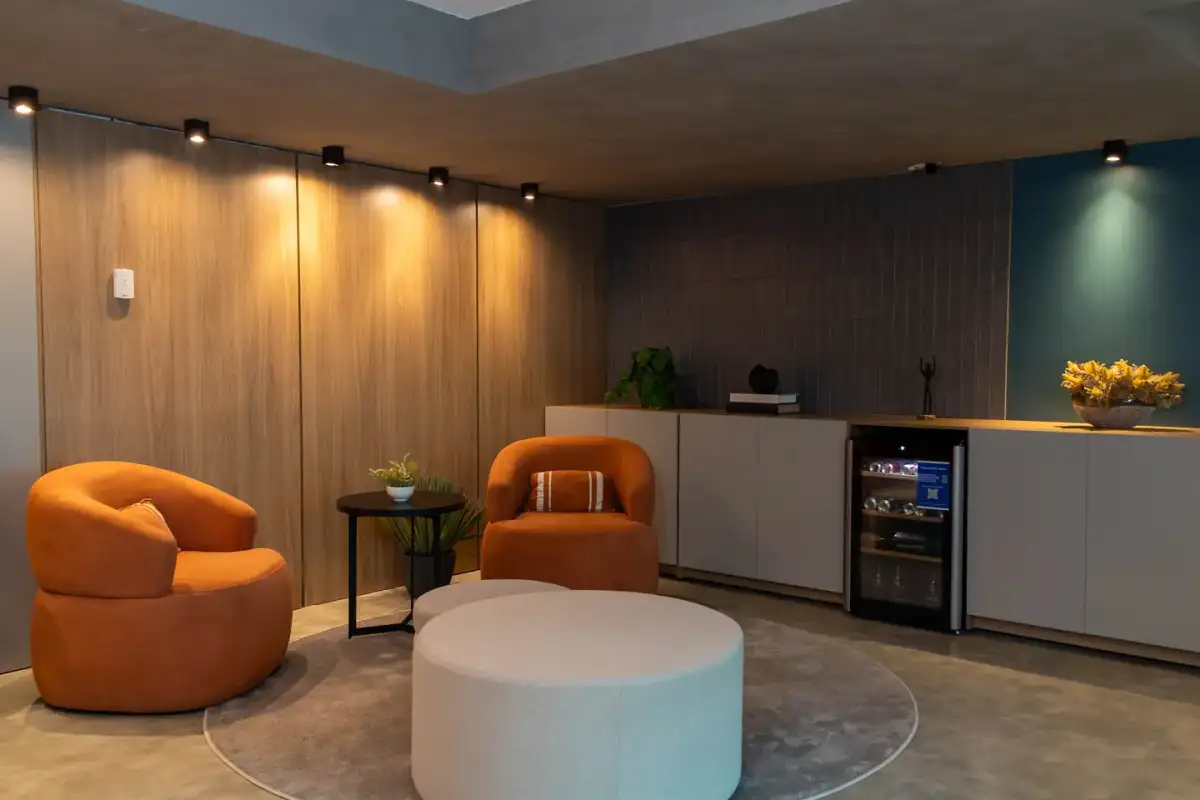 Lounge do 15º andar do Number One com poltronas laranja, pufes claros e painéis de madeira