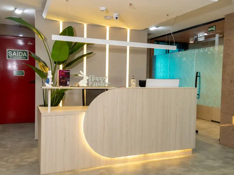 Recepção da unidade Number One com balcão curvo iluminado e plantas