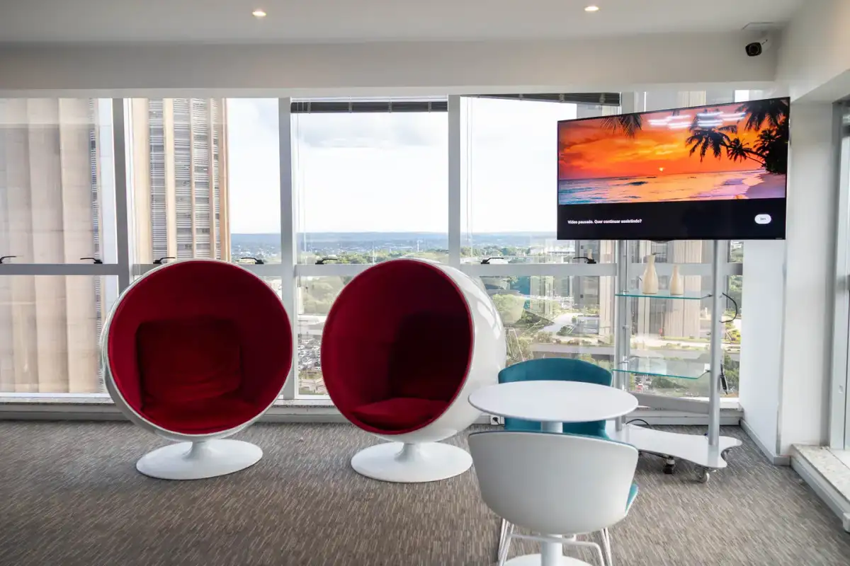 Poltronas vermelhas junto às janelas da unidade Prime Business
