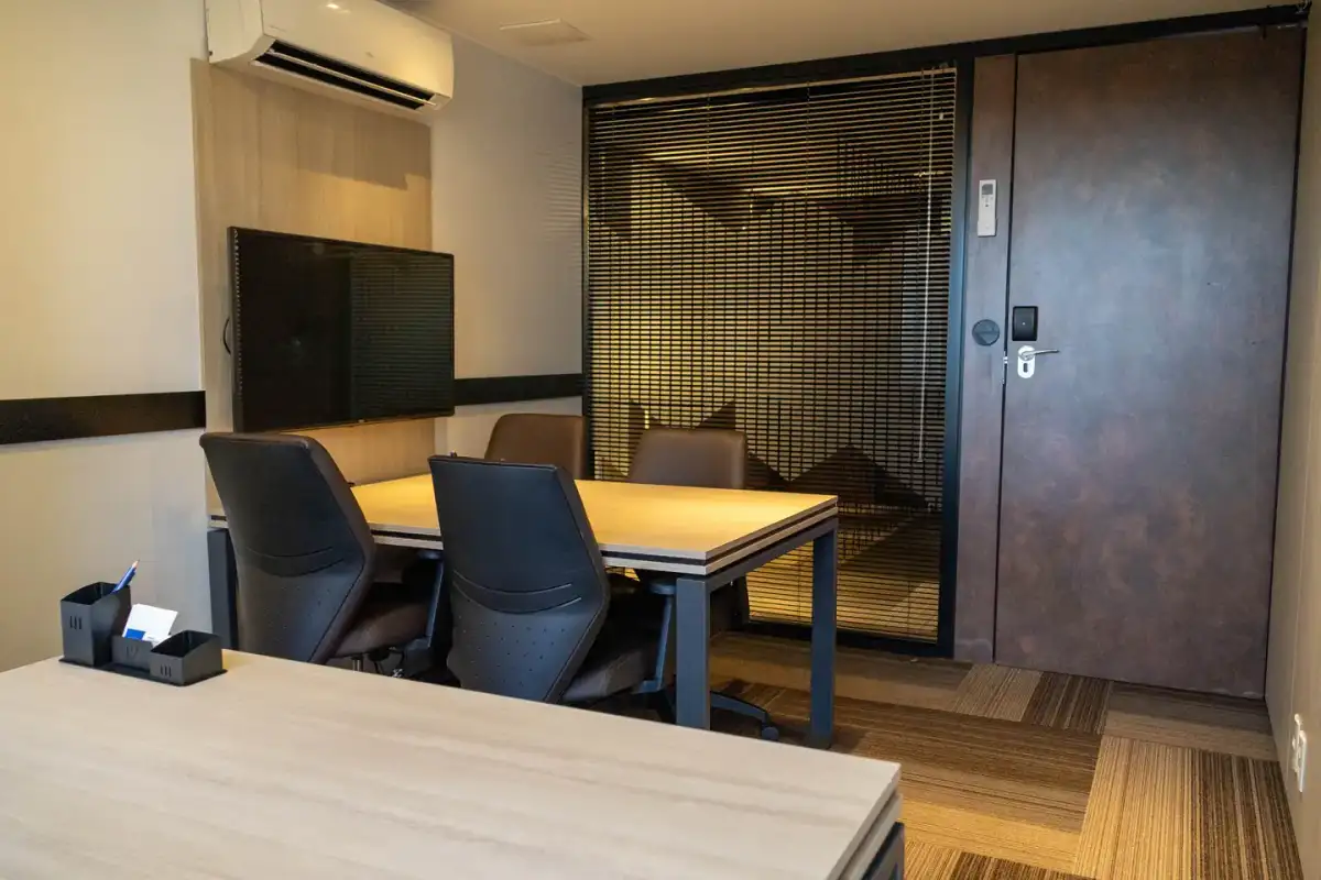 Escritório privativo compacto da unidade Prime Business com mesa, tela e porta com fechadura eletrônica