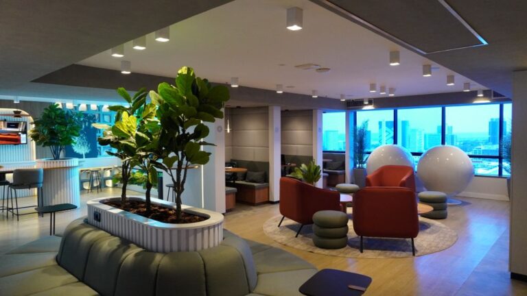 Ambiente de escritório híbrido premium com recepção executiva e salas de reunião modernas.